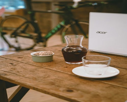 A cup of herbal tea and glasses on a wooden desk