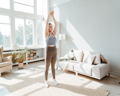 Person doing a gentle stretch in their living room